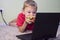 Boy eating a hamburger and playing