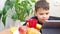 boy eating healthy wholesome breakfast. looks at the tablet, communicates, plays online. croissant, milk, juice. Funny