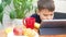 boy eating healthy wholesome breakfast. looks at the tablet, communicates, plays online. croissant, milk, juice. Funny