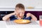 Boy Eating Last Bite of Food at Kitchen Table