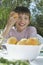 Boy Eating Peach At Garden Table