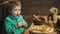 Boy eating pizza on a wooden background. Tasty pizza. Little boy having a slice of pizza. Hungry child taking a bite