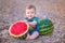 Boy eating watermelon on the beach, summertime enjoying beautiful day close to ocean