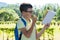 Boy eats an apple and reads an interesting book on his way home from school through the park