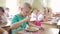 Boy eats cutlet with a fork in preschool