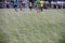 Boy elementary local soccer team practicing tactics and drilling on a green pitch with their coach after a school day in the eveni