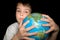 Boy embracing globe of world isolated