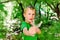 Boy enjoying his summer vacation throwing rocks with a slingshot in a forest