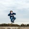 Boy enjoys jumping with his scooter over a ramp