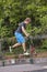 Boy enjoys jumping at the skate park with his push scooter