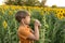 A boy in the evening among the sunflowers in the field sniffs a flower