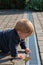 Boy examining gutter in yard