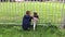 Boy explains rules to girl at football match from fence