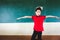 Boy extend the arms with book on head, standing before chalkboard, punishing