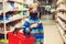 Boy in face mask in supermarket. Kid with shopping basket. Child wears protected mask in shop
