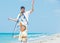 Boy with father on beach playing with a kite