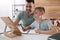 Boy with father doing homework using tablet at table