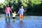 Boy with father and grandfather fly fishing outdoor over river background. Man in different ages. Hobby and sport