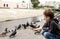 The boy feeds the insolent pigeon with a piece of bread from his