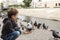 The boy feeds the insolent pigeon with a piece of bread from his