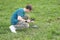 A boy in a field launches a quadcopter and controls it from the remote control