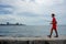 Boy with fishing rod walks along the seawall in Havana