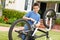 Boy fixing bike in garden