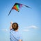 Boy flies kite into blue sky