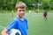 Boy footballer with a ball in a stadium