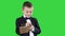 Boy in a formal clothes writing in check list or notebook on a green screen, chroma key.