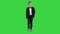 Boy in formal costume walking with a hand in pocket on a green screen, chroma key.