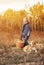 Boy with full basket of mushrooms with dog on the forest glade