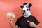 Boy with funny latex cow mask holding money with one hand and pointing to it with the finger of the other hand
