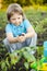 Boy in the garden admires the plant before planting. Green Sprout in Children Hands