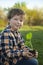 Boy in the garden admires the plant before planting. Green Sprout in Children Hands