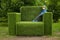Boy on the giant grass armchair, park landscape decoration