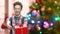 Boy with gift box on blurred Christmas background.