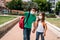 Boy and girl with backpacks and masks going to school in coronavirus pandemic