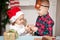 Boy and girl brother and sister give each other christmas gifts