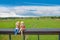 boy and girl cartoons dolly on wooden seat with the green paddy rice field, the beautiful sky cloud,