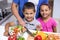 Boy and girl chopping vegetables in the kitchen