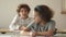 Boy and girl classmates are sitting in the classroom at their desks. The boy asks the girl for a leaflet. Back to school