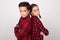 Boy and girl with crossed arms posing back to back with challenging look