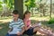 A boy and a girl do their homework in the park and get ready for school together