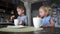 A boy and a girl drink tea from large mugs in the family kitchen and eat croissants. European interior.