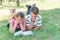 A boy and a girl are engaged in education, classmates together read from one textbook, the book lies on the grass