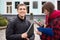 Boy and girl exchanging phone numbers at street