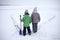 Boy and girl have fun and removing snow from the ice on the frozen lake in heart shape