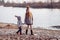 A boy and a girl having fun outside in early spring in the forest near the water. A sister and brothe together.