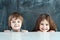 Boy and girl hiding behind a table